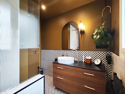 Salle de bain rénovée à Bouaye avec carrelage pétale noir et blanc, vasque unique et espace coiffeuse, décoration intérieure contemporaine